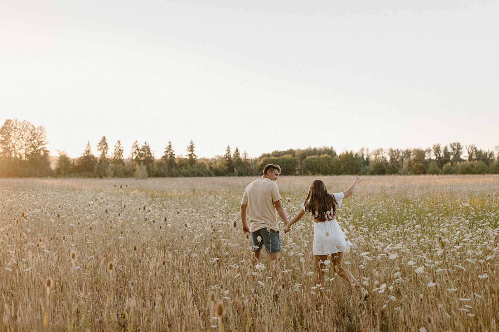 couples running in a field at sunset in oregon